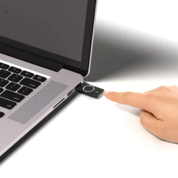 YubiKey Bio insérée dans le port USB-A d'un ordinateur portable, doigt approché du lecteur d'empreinte