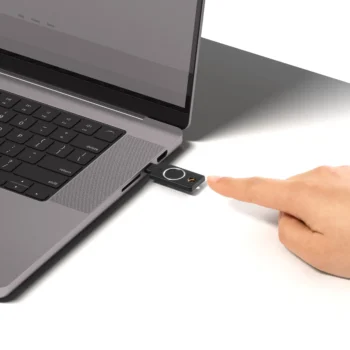 YubiKey C Bio branchée sur le port USB-C d'un ordinateur portable, doigt approché du lecteur d'empreinte