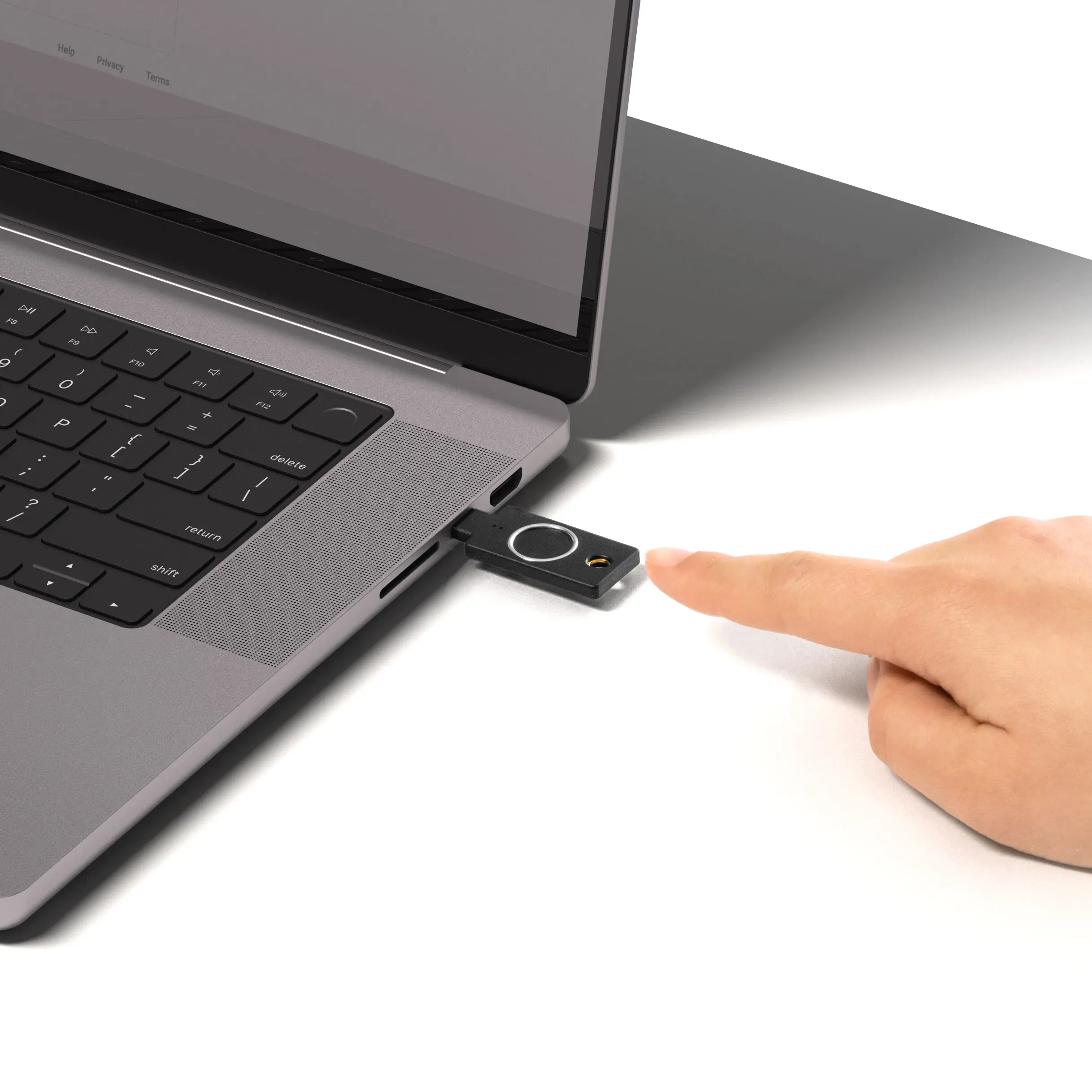 YubiKey C Bio branchée sur le port USB-C d'un ordinateur portable, doigt approché du lecteur d'empreinte