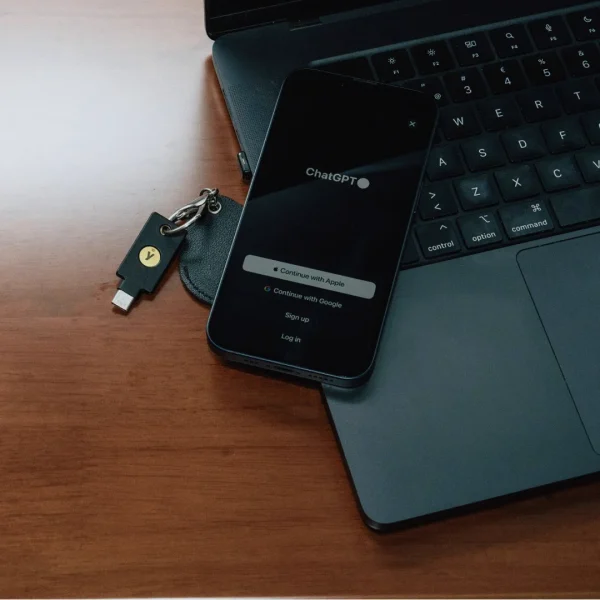 Clé de sécurité YubiKey USB-C de l'édition OpenAI posée devant un ordinateur portable
